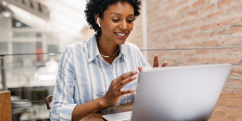 Woman sitting in front of her laptop and learning to speak a foreign lanuage