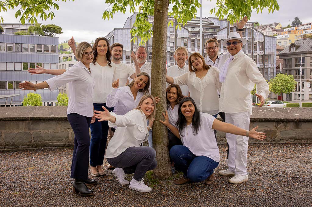 Team of inlingua Ostschweiz presented infront of a tree. Everbody wears a white shirt.