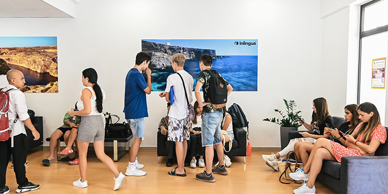 Entrance of inlingua Malta with a lot of learners, having a break or chatting before classes