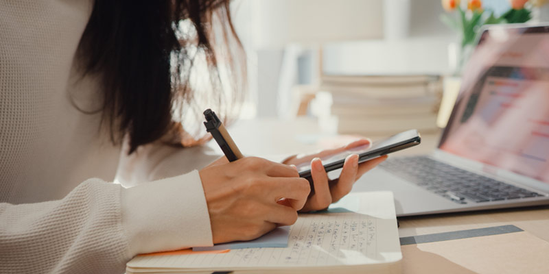 Woman checking her smartphone while learning
