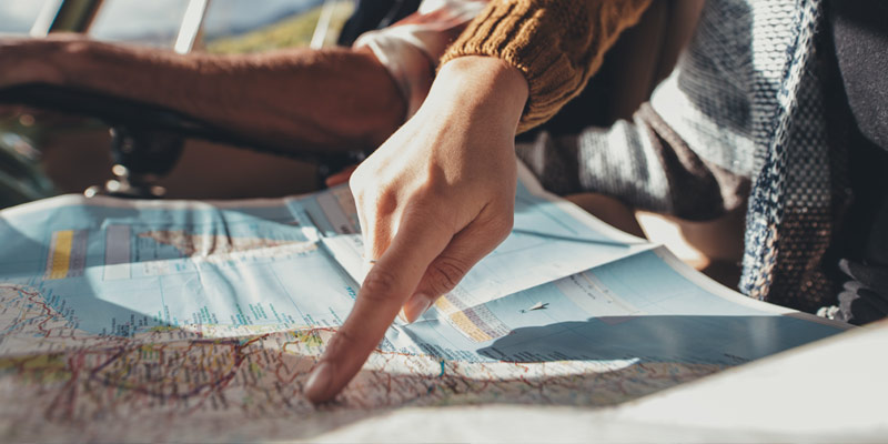 Finger pointing on a city on a map