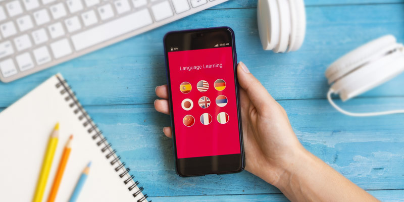 Smartphone showing a language learning app with country flags.