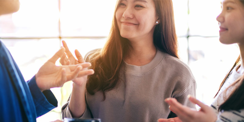 People engaged in a real-life conversation, using gestures and facial expressions