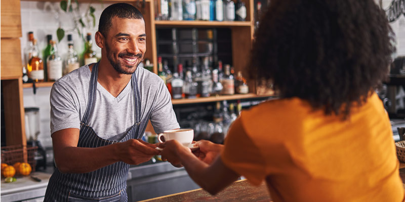 Barista and customer interacting in a café, demonstrating real-life communication