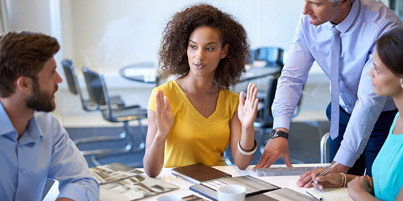 Woman confidently expressing ideas with colleagues during a meeting