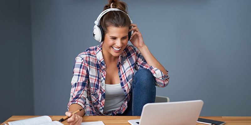 Woman studying a language online with headphones – interactive language learning