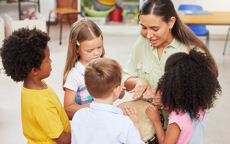 Children learning a foreign language through songs and rhythmic activities with a language trainer