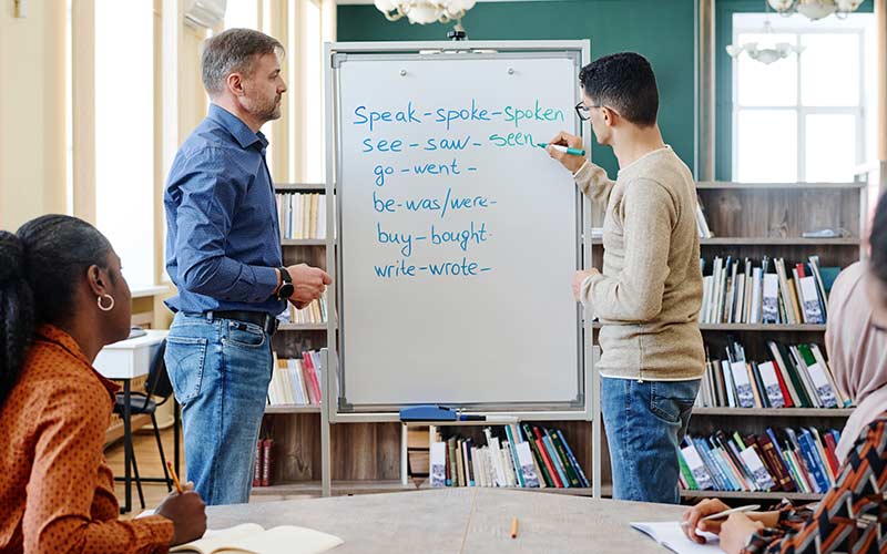 Learners engaged in traditional language learning activities, highlighting the limitations of grammar-focused instruction for real-world communication