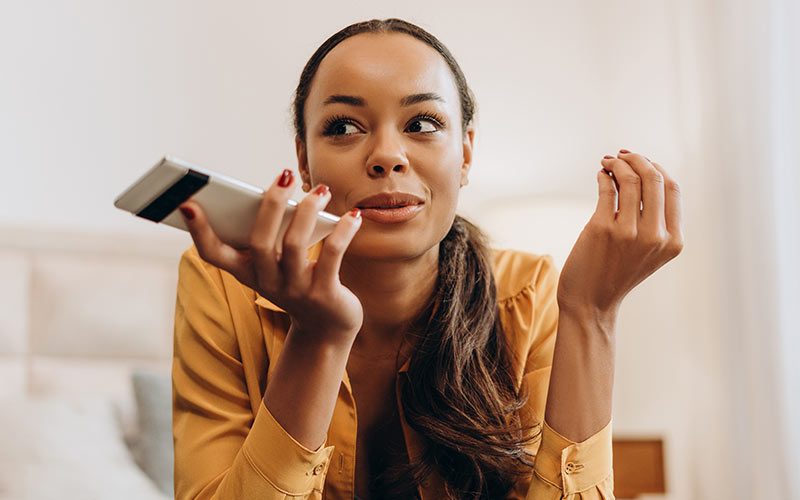 Language learner practicing speaking skills independently by recording their voice on a smartphone