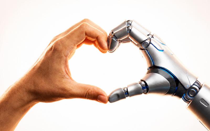 Human and robotic hands forming a heart shape, symbolizing collaboration in the age of AI