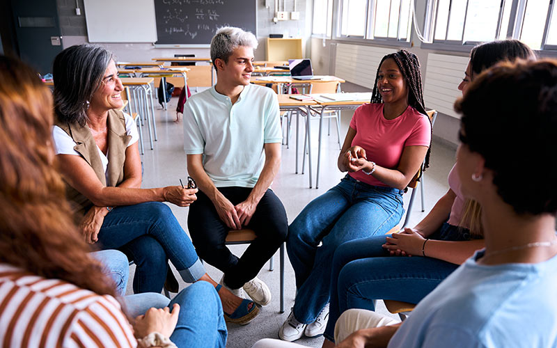 Language learners participating in an interactive in-class discussion with their trainer
