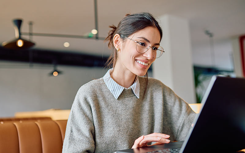 Employee using a laptop for flexible language learning alongside a busy work schedule