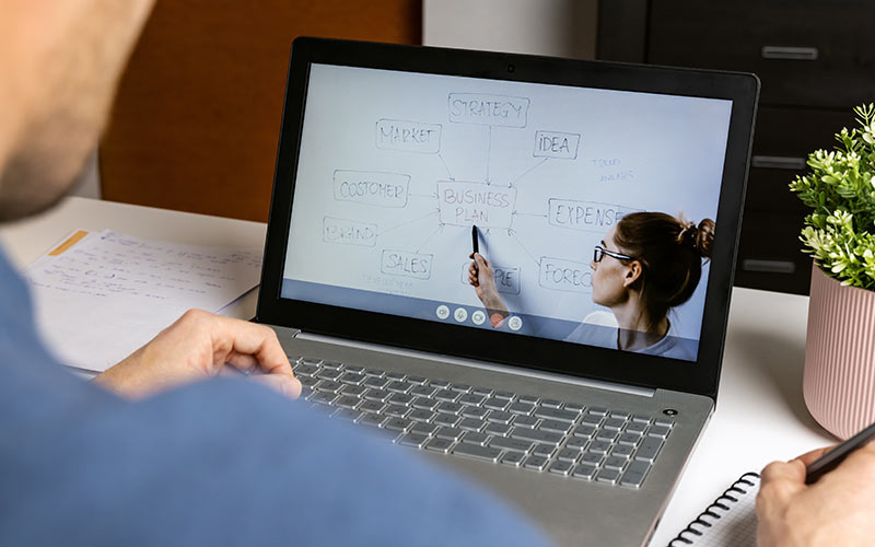 Learner using interactive technology during an online language lesson with a trainer