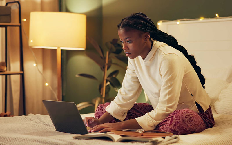 Learner studying online from home with a laptop at a time that suits her